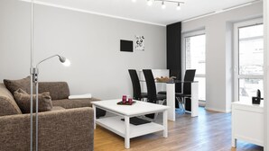 Una sala de estar moderna con un sofá, una mesa de centro y un comedor con sillas y una mesa.