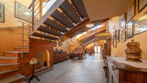 A spacious interior with a grand staircase, wooden furniture, and a chandelier. - Wine-Farm La Source (Saint-Pierre)
