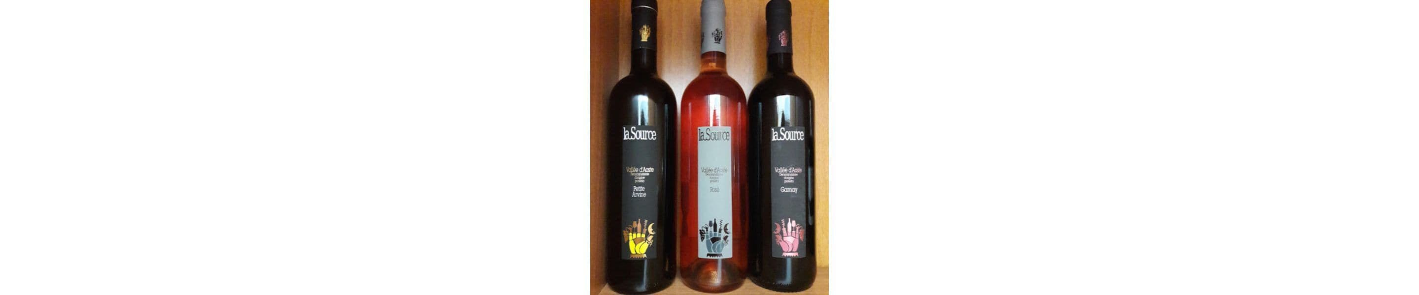 Three bottles of La Source wine with labels indicating different types of wine.