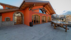A building with a stone facade, wooden beams, and a large wheel. - Wine-Farm La Source (Saint-Pierre)
