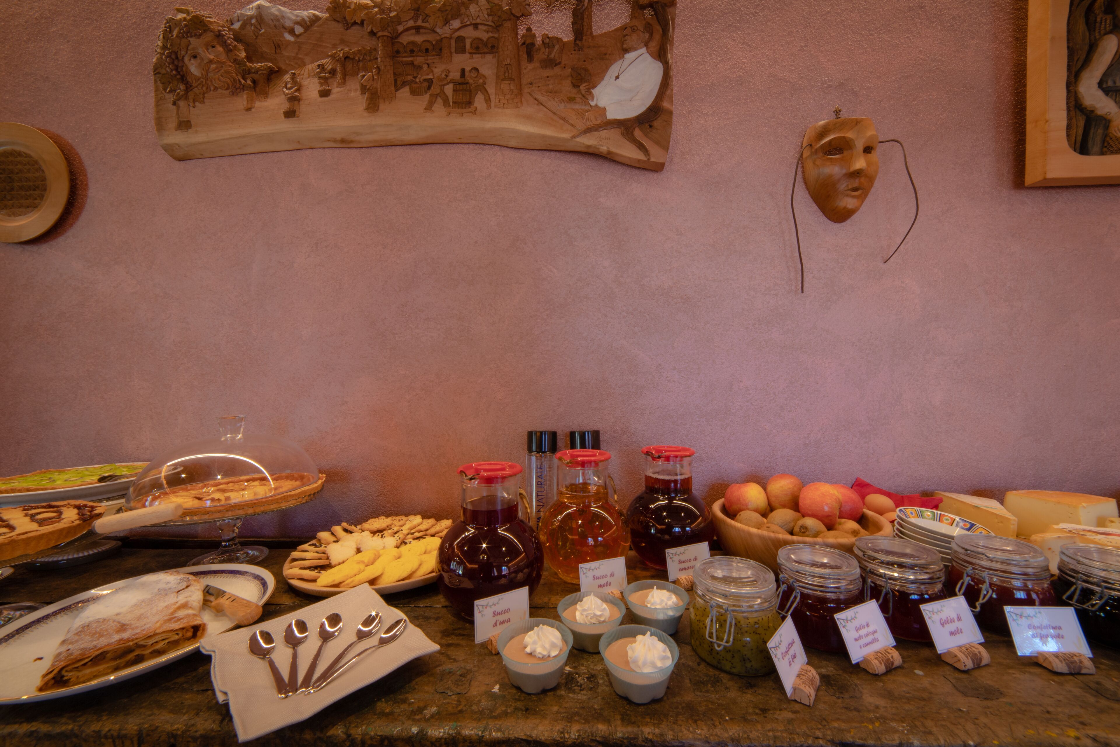 A buffet table with various food items, including fruits, cheeses, and condiments.