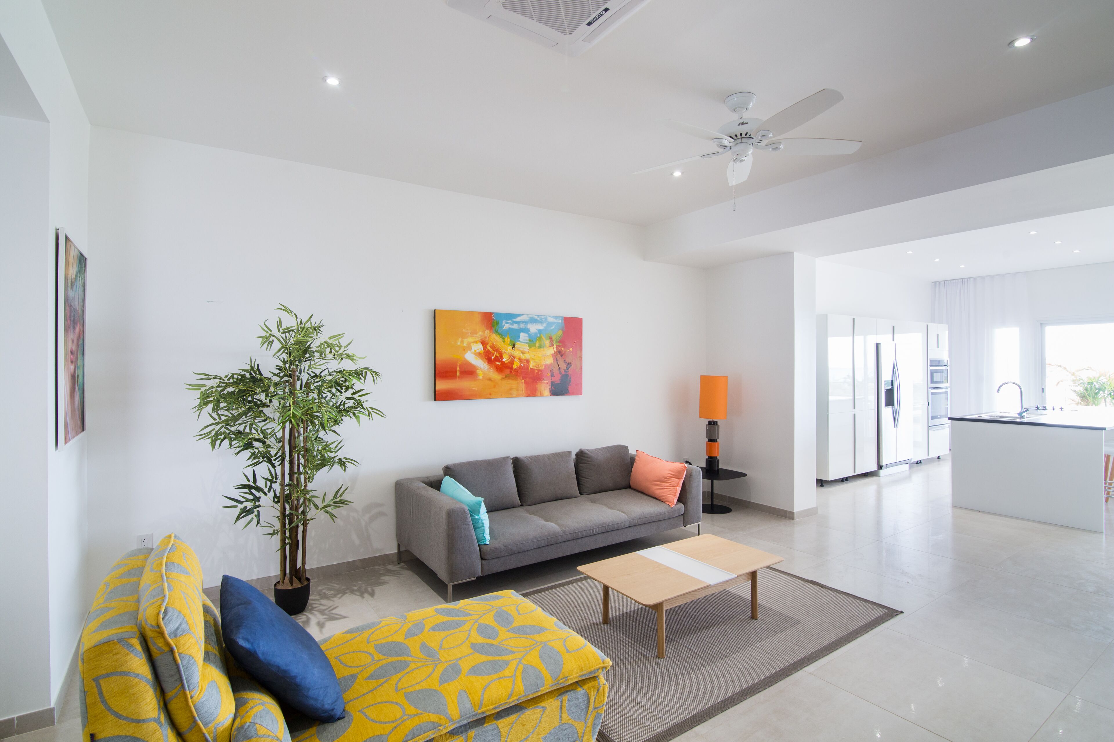 A modern living room with a sofa, a coffee table, a floor lamp, and a painting on the wall.