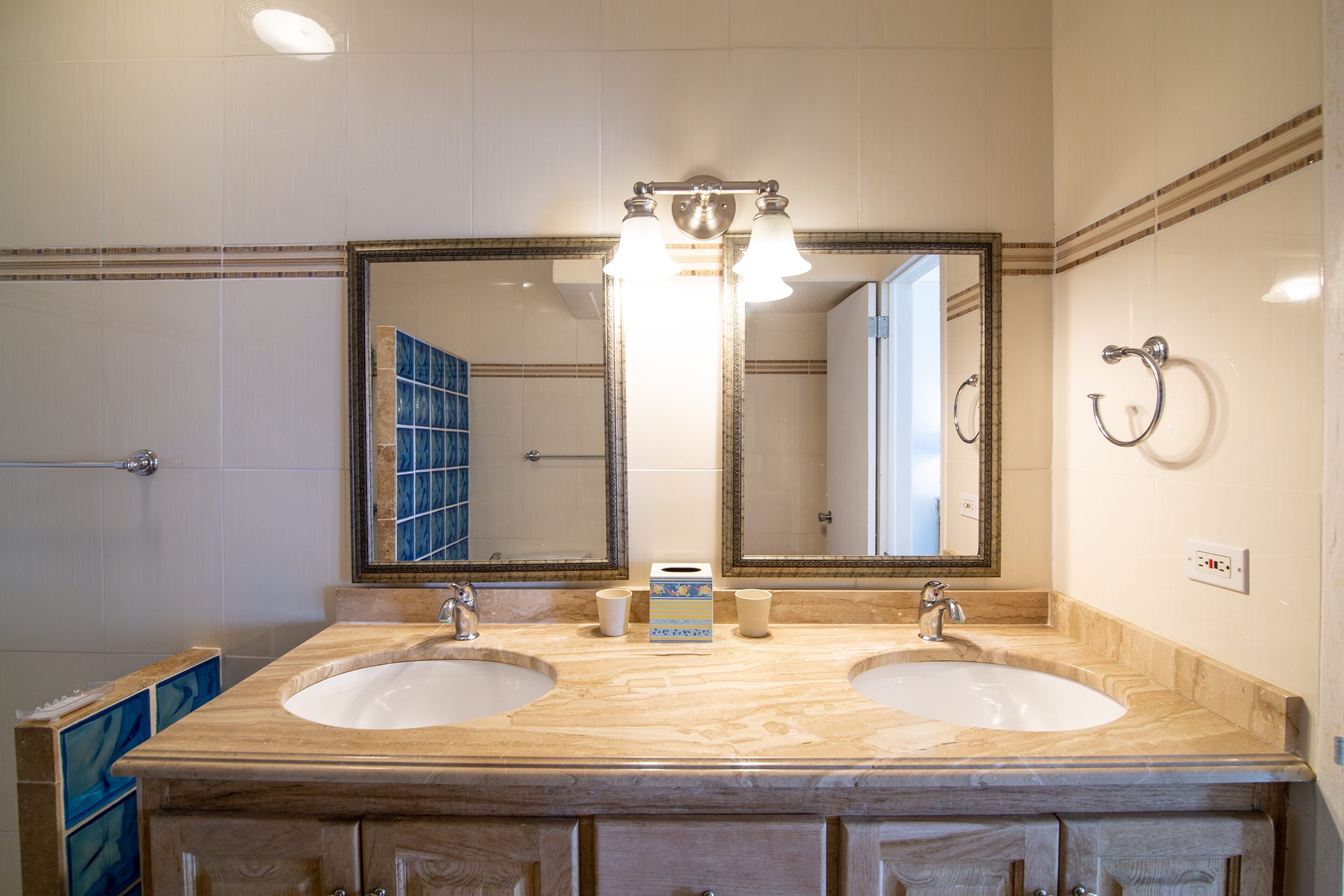 A bathroom with two sinks, a large mirror, and a towel rack.