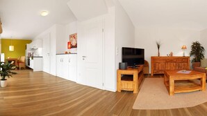 A modern living room with a television, sofa, and coffee table. - Apt. Strandschnecke - Dream apartment with partial harbor views! (Insel Poel / OT Timmendorf Strand)