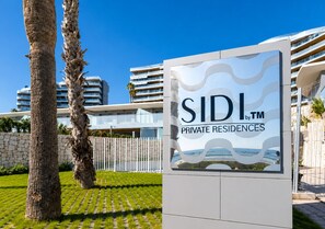 A sign for SIDI Private Residences with a modern architectural background. - Apartment in SIDI Resort Playa San Juan (Alicante)