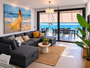 Ein modernes Wohnzimmer mit einer Couch, einem Couchtisch und einem Bild einer Frau am Meer.