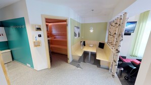 A modern room with a wooden sauna, a small table, and a bench. - Pension Trojerhof (Heiligenblut)