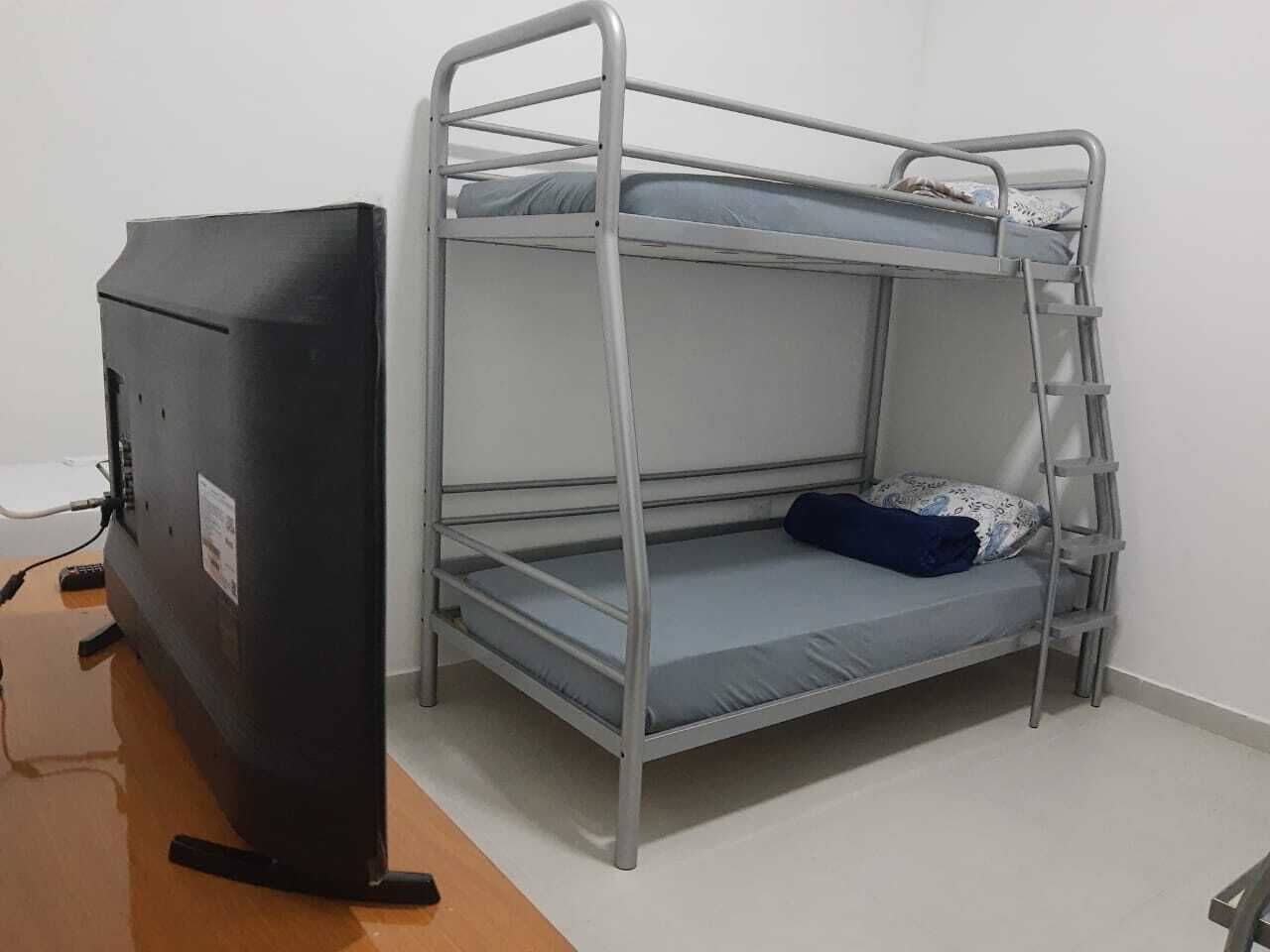 Una cama litera con escritorio y televisor.