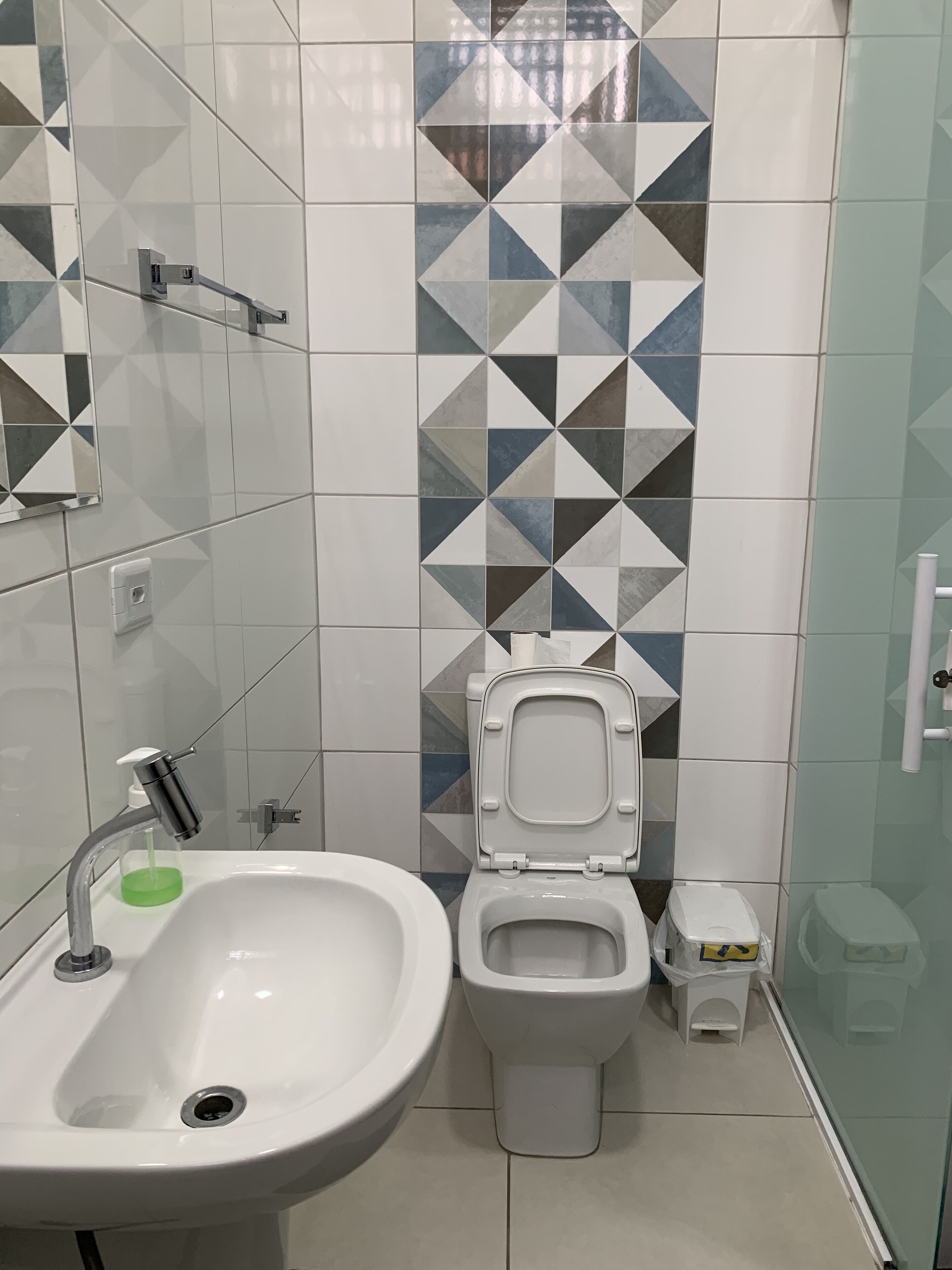 A bathroom with a white sink, a toilet, and a shower area.