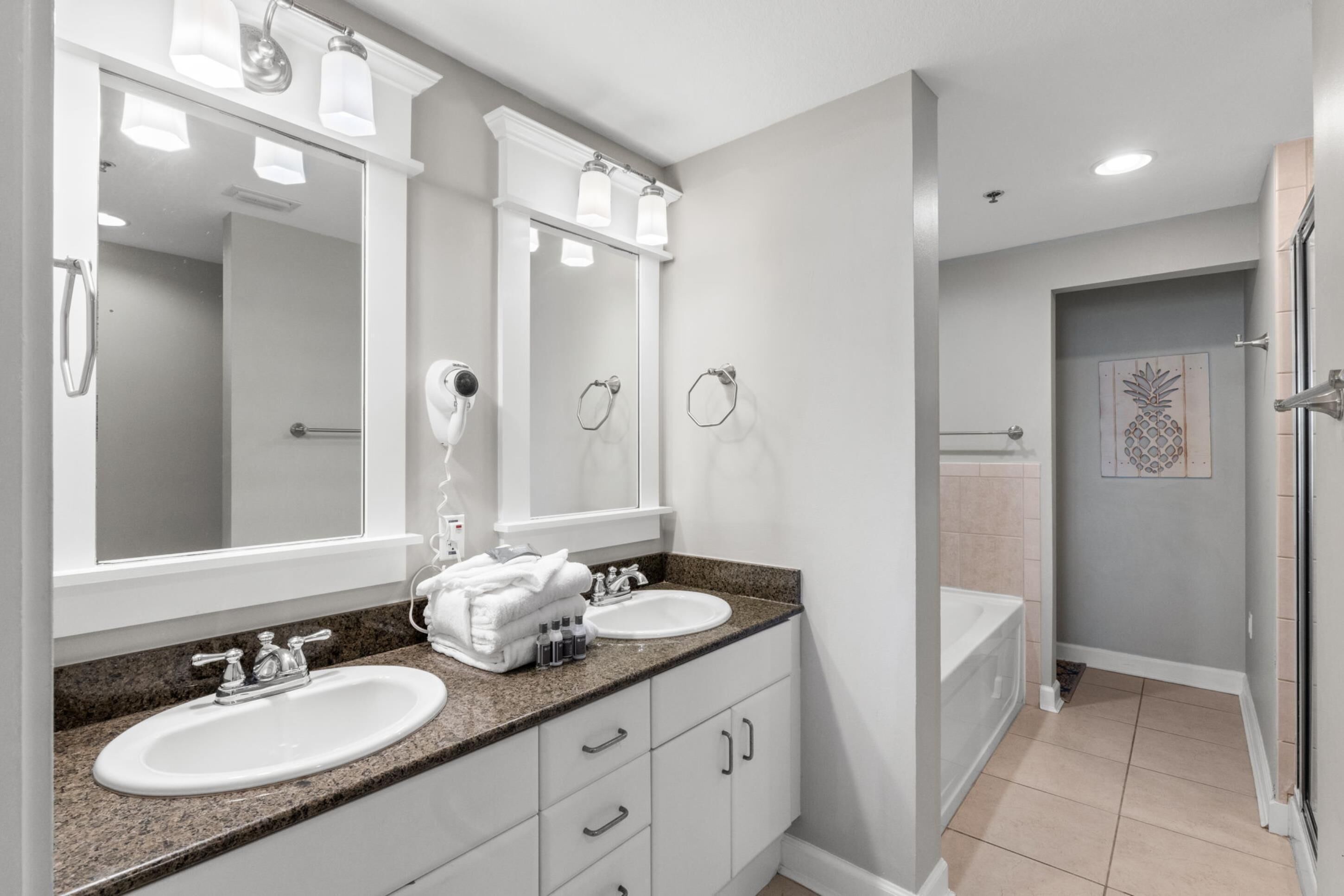 Un baño moderno con dos lavamanos, un espejo grande y una zona de ducha.