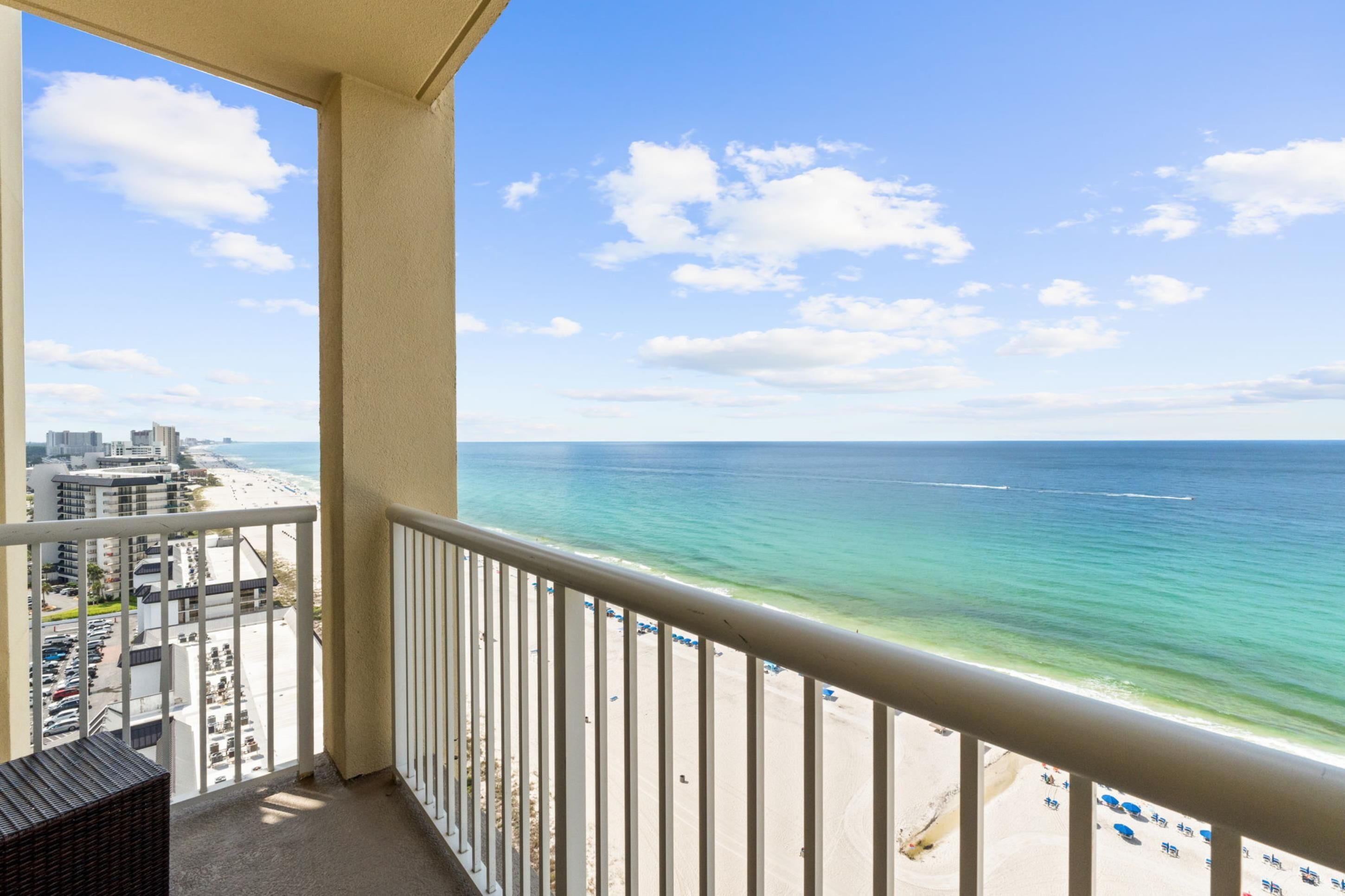 A balcony with a view of the beach and ocean.