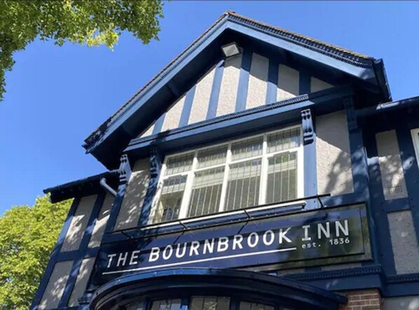 The Bournbrook Inn with a classic architectural style, featuring a prominent gabled roof and large windows.