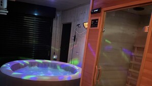A hot tub with a control panel and a wooden sauna room.