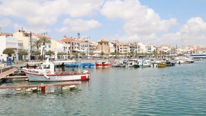 A marina with boats docked, a clear sky, and buildings in the background. - Villa Paradis Costa Dorada (Miami Playa)