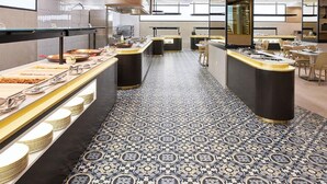 A modern restaurant with a patterned floor, black and white decor, and a central serving area. - Gold Arcos (Benidorm)