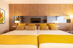 A hotel room with two beds, wooden paneling on the walls, a large mirror, and a painting on the wall. - Gold Arcos (Benidorm)