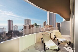 A balcony with two sun loungers, a small table, and a view of the cityscape. - Gold Arcos (Benidorm)