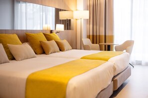 A hotel room with two beds, a sitting area with a table and chairs, and a large window with curtains. - Gold Arcos (Benidorm)
