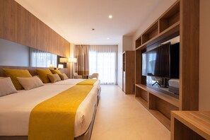 Une chambre d’hôtel avec un grand lit, une télévision et un coin salon.