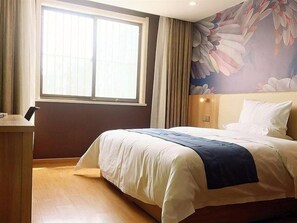 A hotel room with a large bed, a desk, and a window with curtains. - PAI Hotels Yulin Second Street South Gate (Yulin)