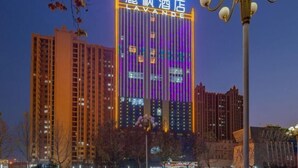 A hotel with a prominent illuminated sign in a foreign language, surrounded by high-rise buildings. - Lavande Hotel (Heze Dingtao) (Heze)