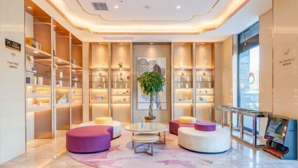 A modern lobby with a central seating area, a large plant, and a glass display case. - Lavande Hotel (Heze Dingtao) (Heze)