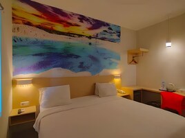 Habitación de hotel con cama, mesitas de noche, un escritorio y un cuadro abstracto grande en la pared.