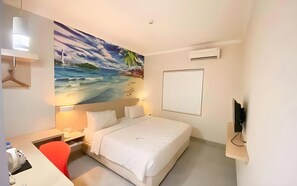 A hotel room with a bed, a desk, a chair, a painting of a beach scene, and a television on a stand. - Cordela Hotel Pangkal Pinang (Pangkalpinang)