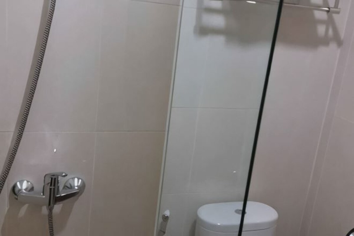 Un baño con cabina de ducha de vidrio, inodoro y ducha.