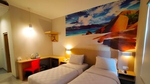 Habitación de hotel con dos camas, un escritorio y un cuadro de un paisaje.