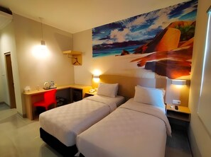 Habitación de hotel con dos camas, un escritorio y un cuadro de un paisaje.