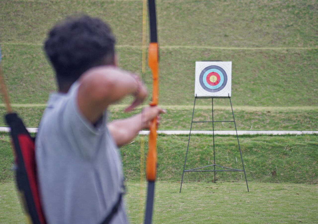 A person aiming an arrow at a target.