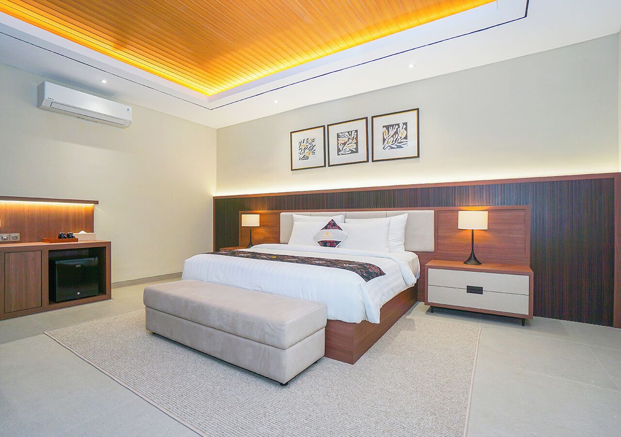 A modern bedroom with a bed, bedside tables, a bench, and artwork on the wall.