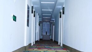 Un passadís amb una catifa colorida i una escala al final.