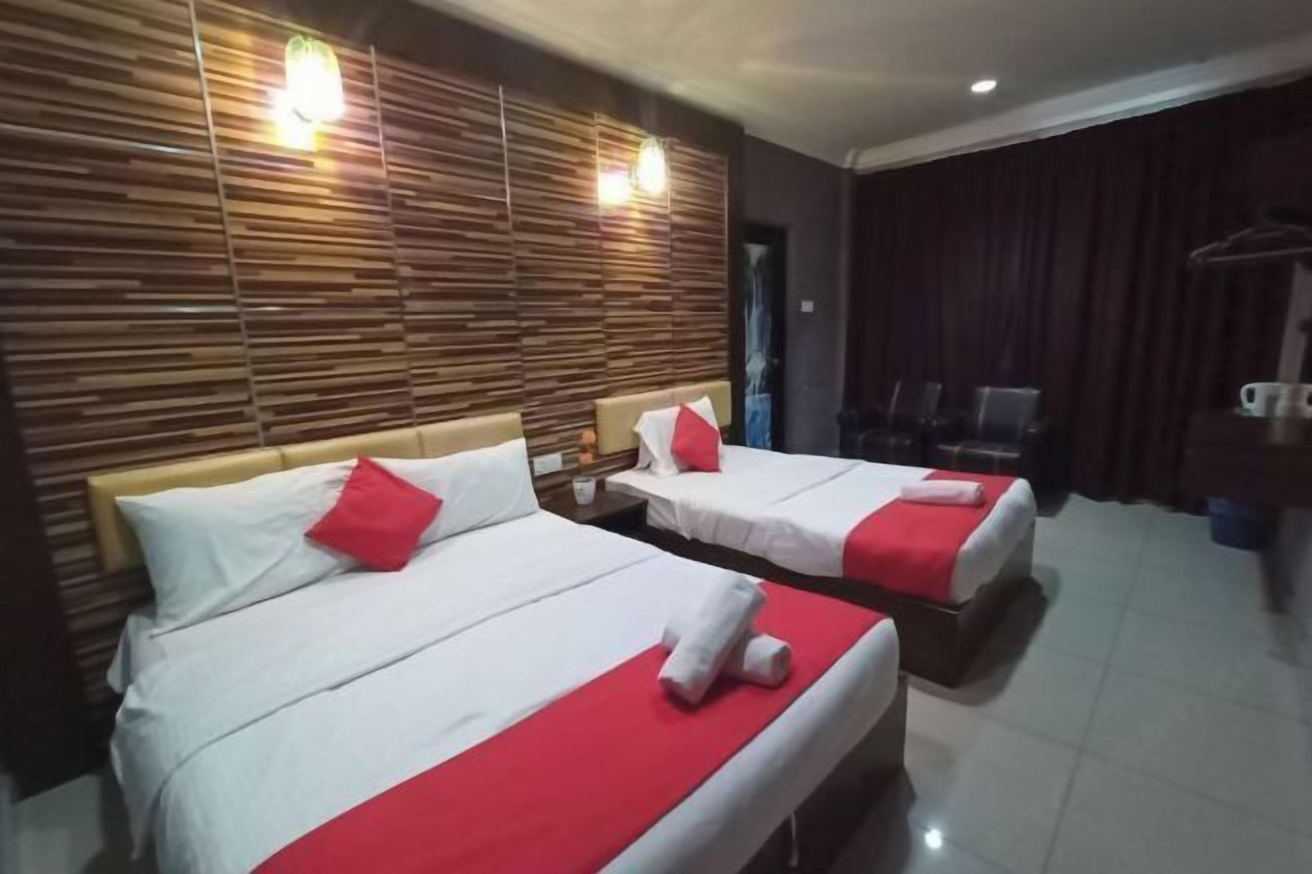A hotel room with two beds, a wooden headboard, a dark curtain, and a coffee machine.