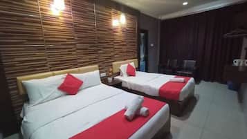 A hotel room with two beds, a wooden headboard, a dark curtain, and a coffee machine.