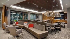 Un espace de détente moderne avec un canapé incurvé, des fauteuils et une table à manger.