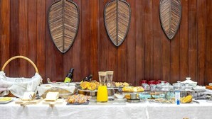 Una mesa de buffet con diferentes alimentos y una botella de jugo de naranja.