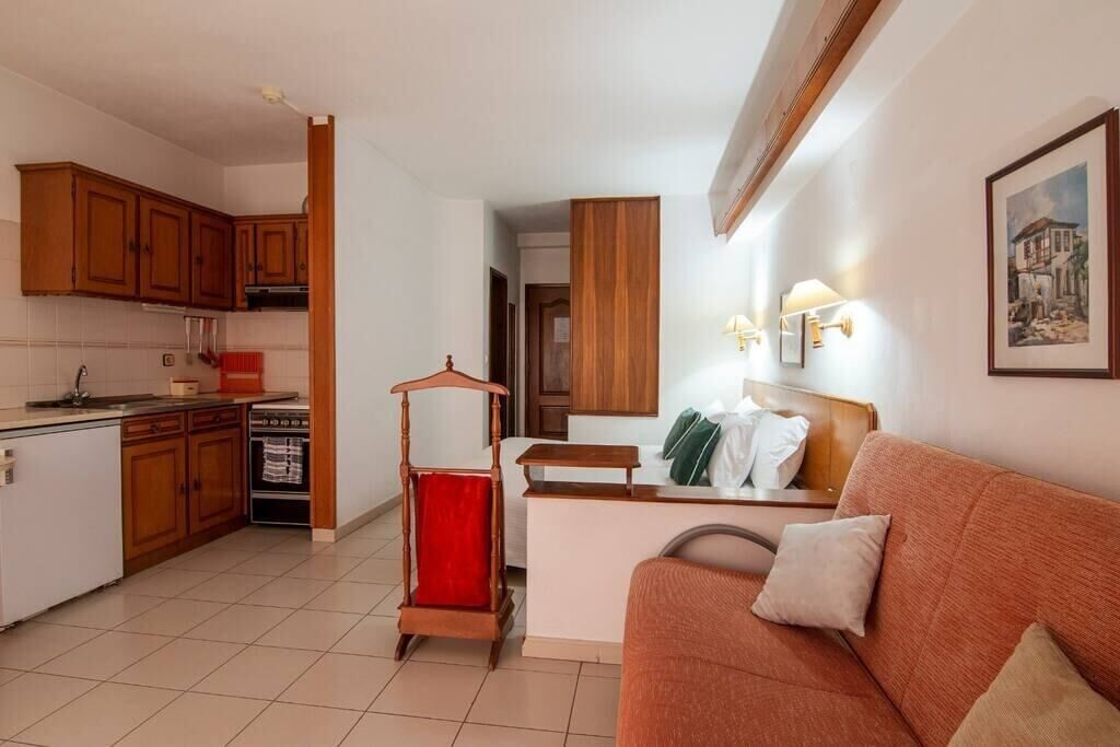 A compact living space with a kitchenette, a dining area, and a sofa.
