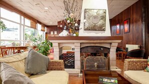 Un vestíbulo acogedor con chimenea, asientos cómodos y un letrero que dice 'Room Service'.