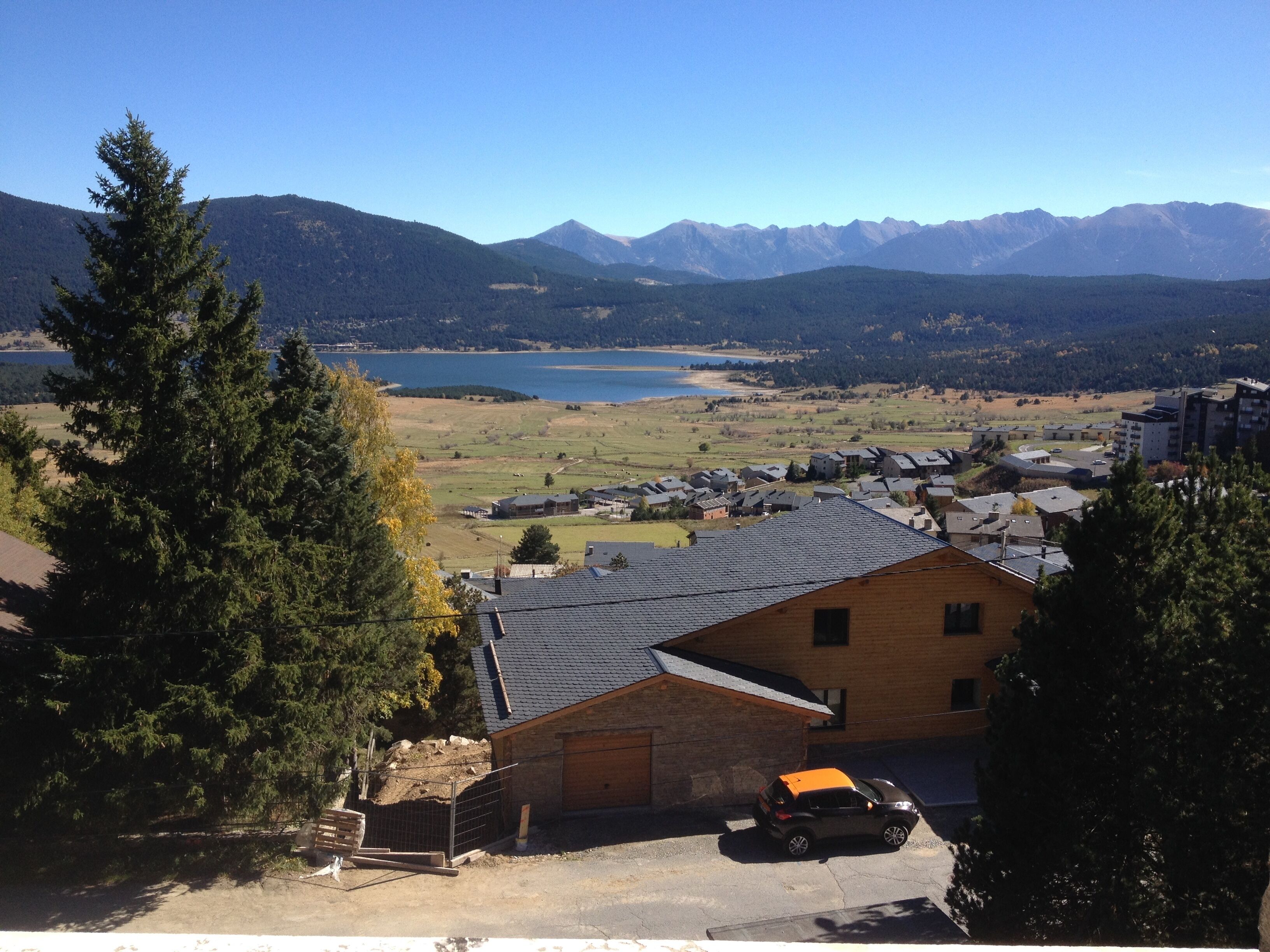 A residential area with houses, a lake, and mountains in the background.