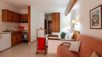 A compact living space with a kitchenette, a dining area, and a sofa.