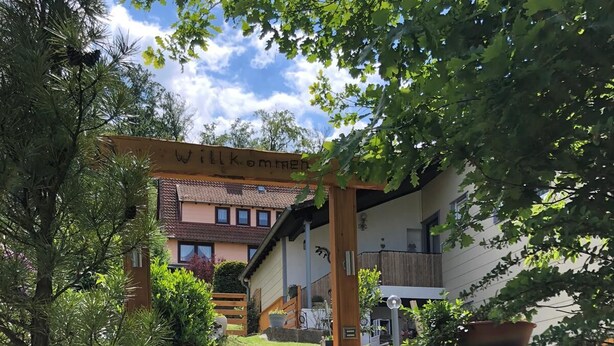 A wooden gate leading to a building with a sloped roof and a balcony. - Beautiful and spacious holiday home (Bad Harzburg)
