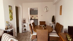 A dining area with a round table, wicker chairs, and a clock on the wall. - Beautiful and spacious holiday home (Bad Harzburg)