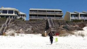 A beachfront property with a staircase leading to a building with multiple balconies. - Seamist #6-Oceanfront-Wonderful View! (Seacrest)
