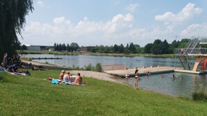A lakeside park with a swimming area, picnic tables, and a grassy area for relaxation. - Restaurant El Greco (Gundelfingen an der Donau)