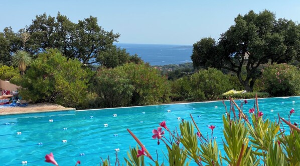 Relax by the serene pool surrounded by lush greenery and breathtaking sea views.