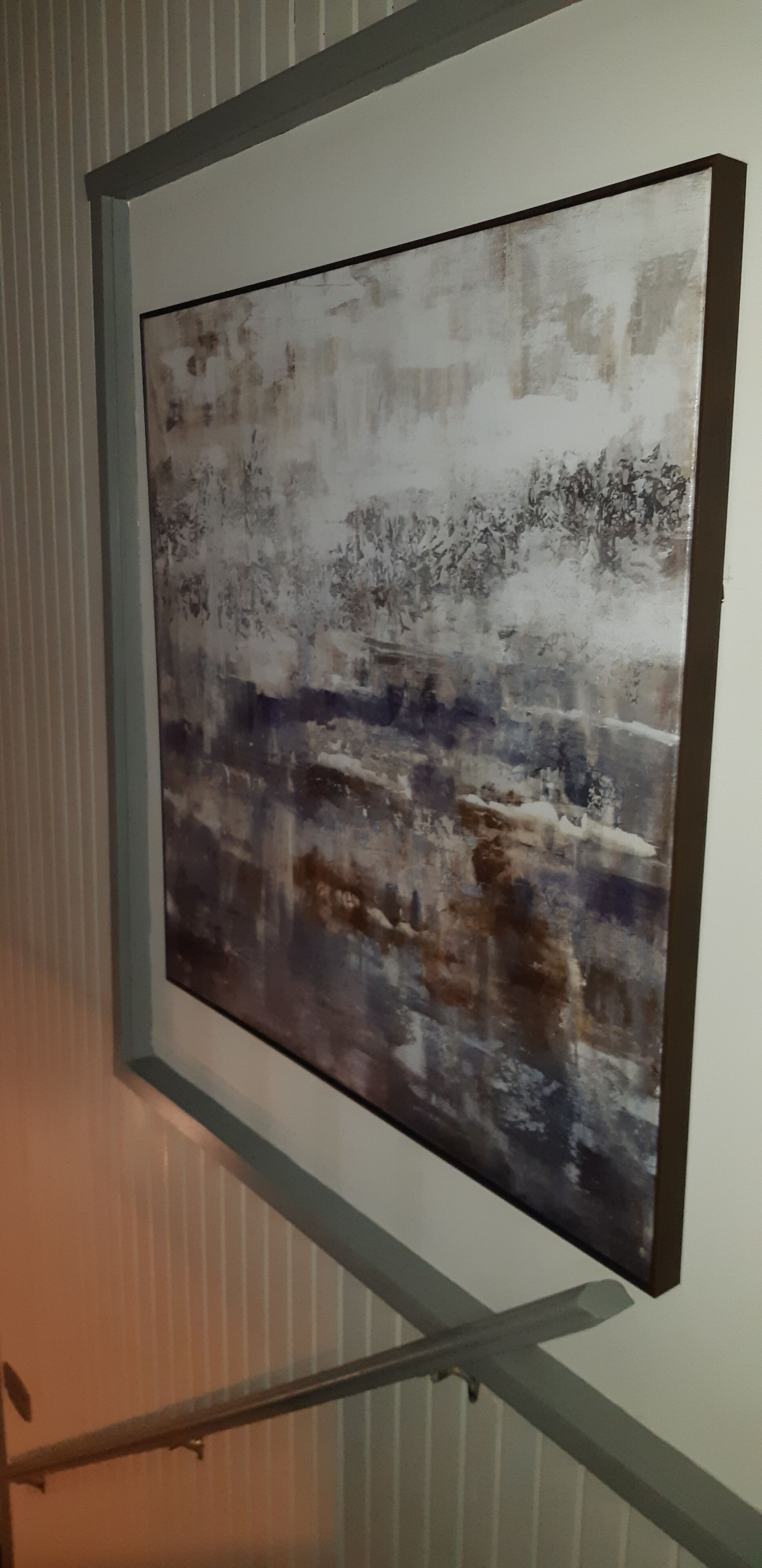 A framed abstract painting on a wall.
