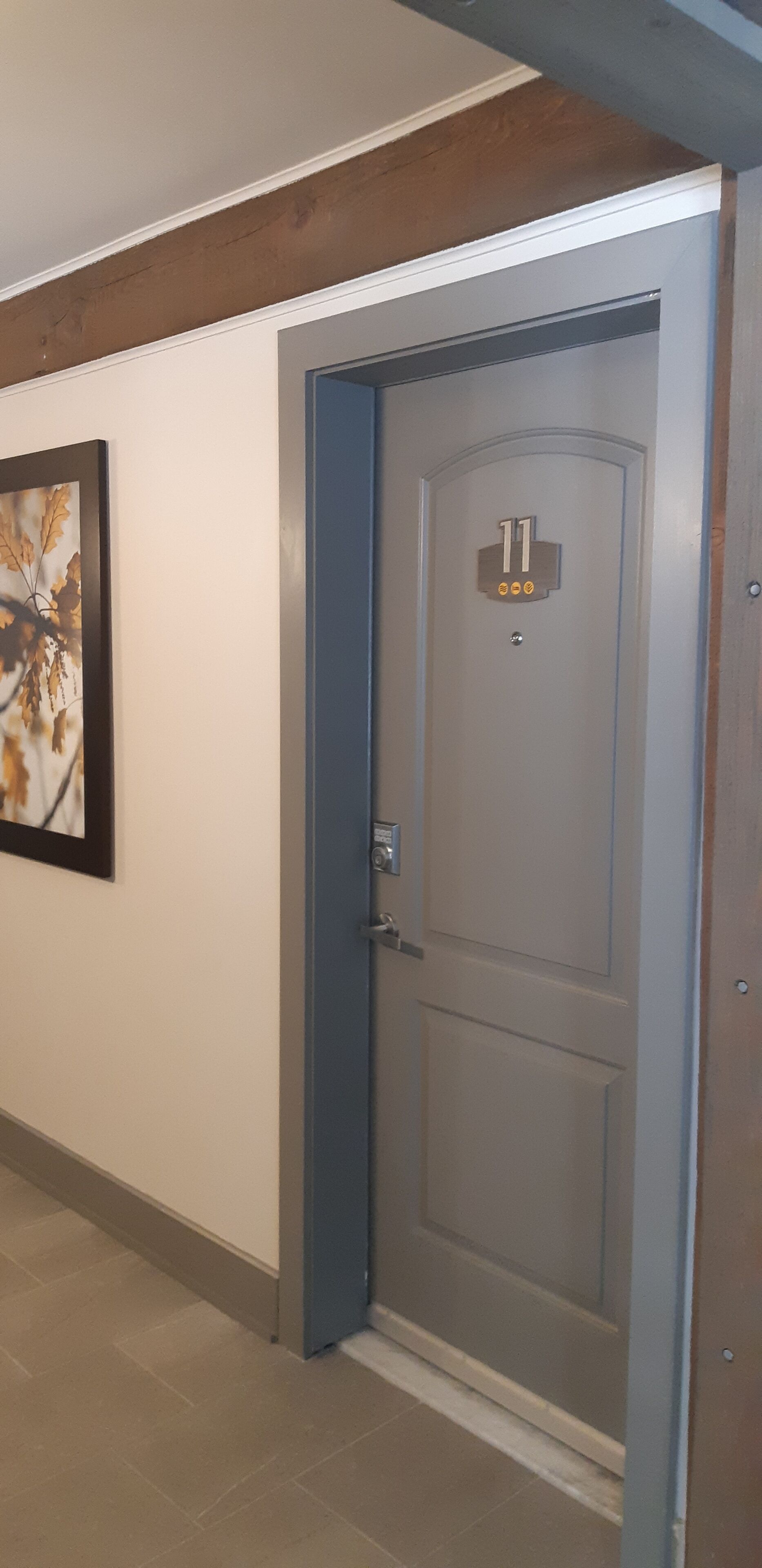 A hallway with a door marked "11" and a framed picture on the wall.