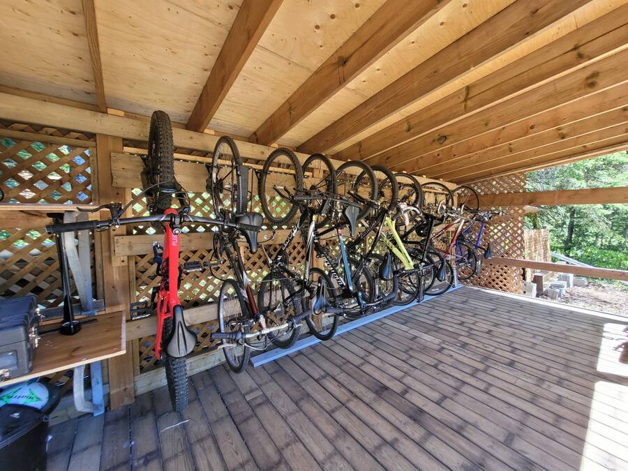 Una terraza cubierta de madera con bicicletas en soportes.